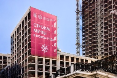 На баннерных сетках и башенных кранах столицы появились новогодние поздравления