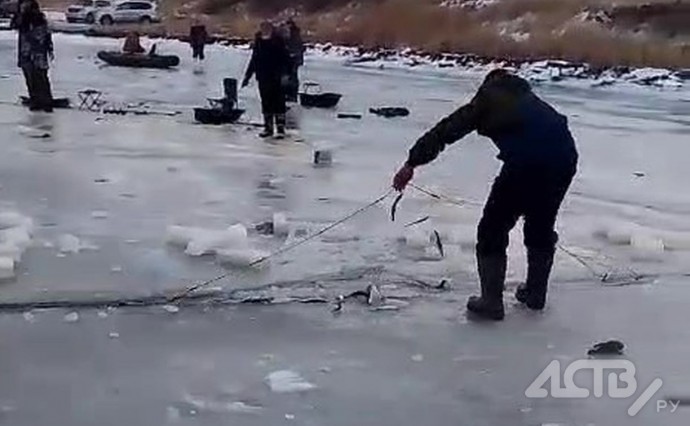 Сахалинские рыбаки достают браконьерские сети из-под неокрепшего льда